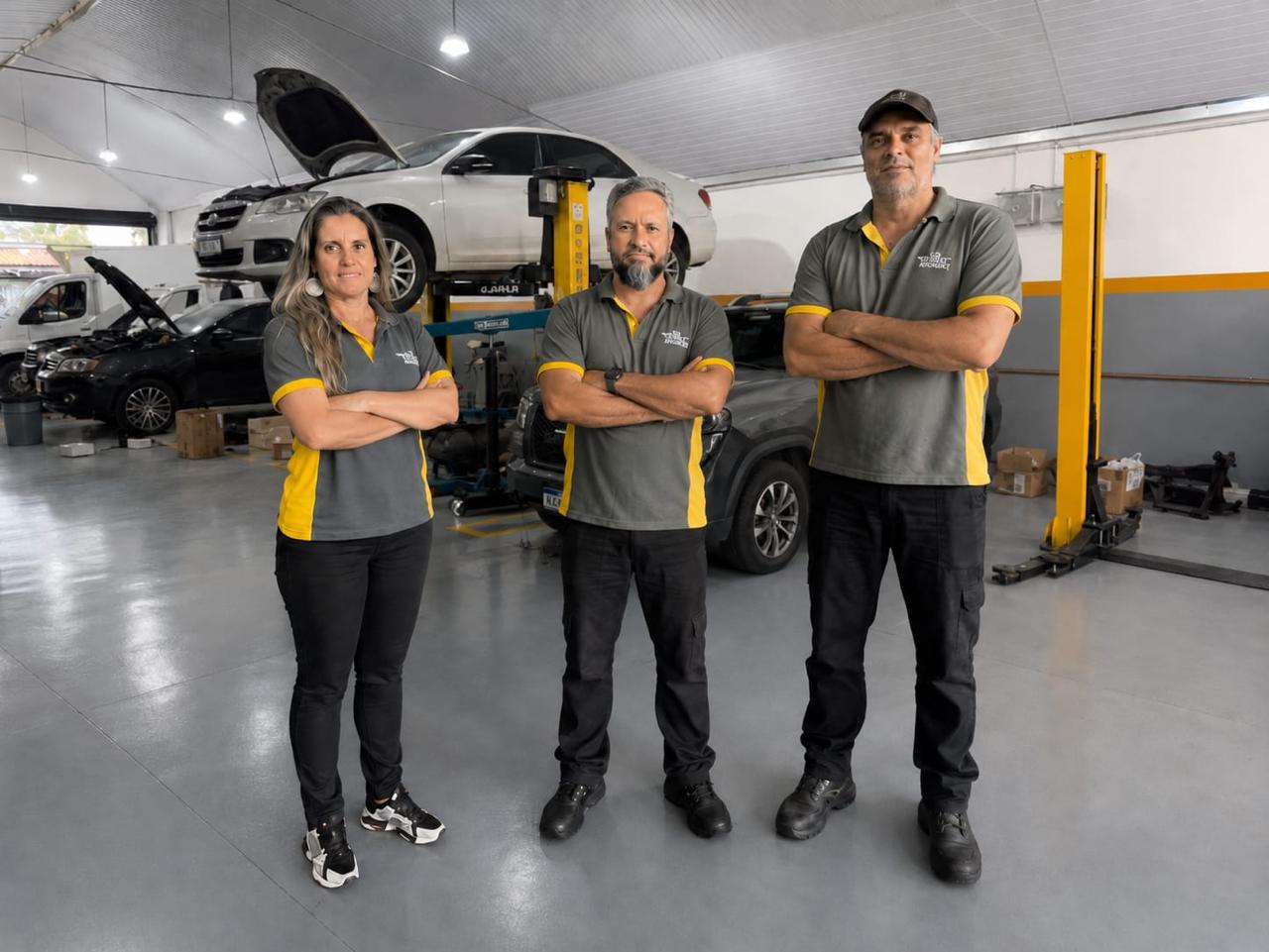 Equipe da Goes Monkey no box da oficina, com carros no elevador ao fundo, em Piracicaba